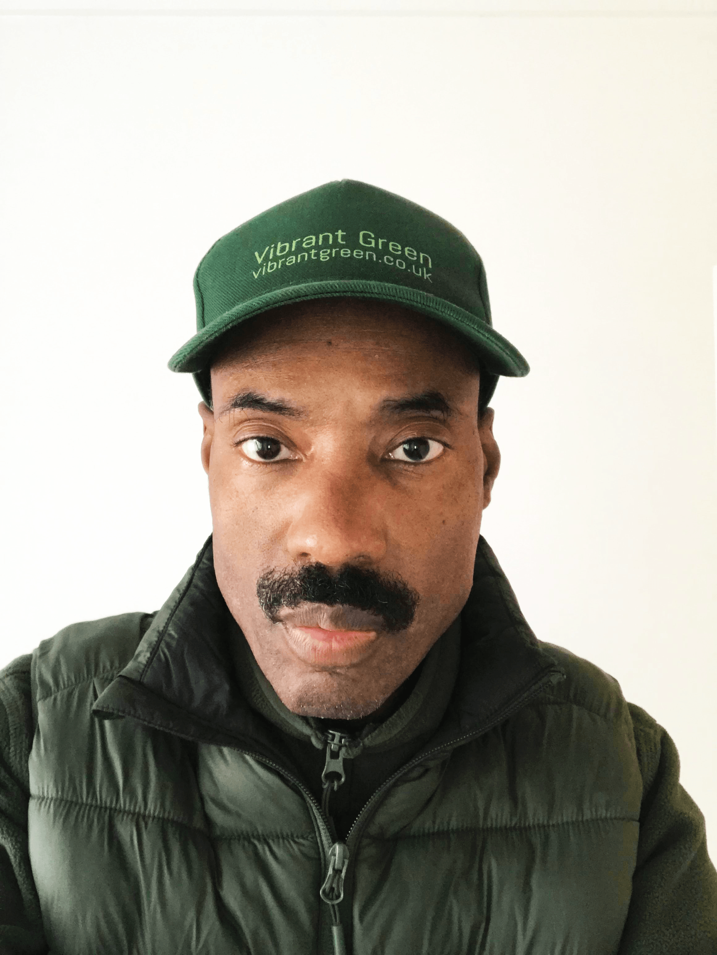Mann mit grünem Cap und grünem Jacke.