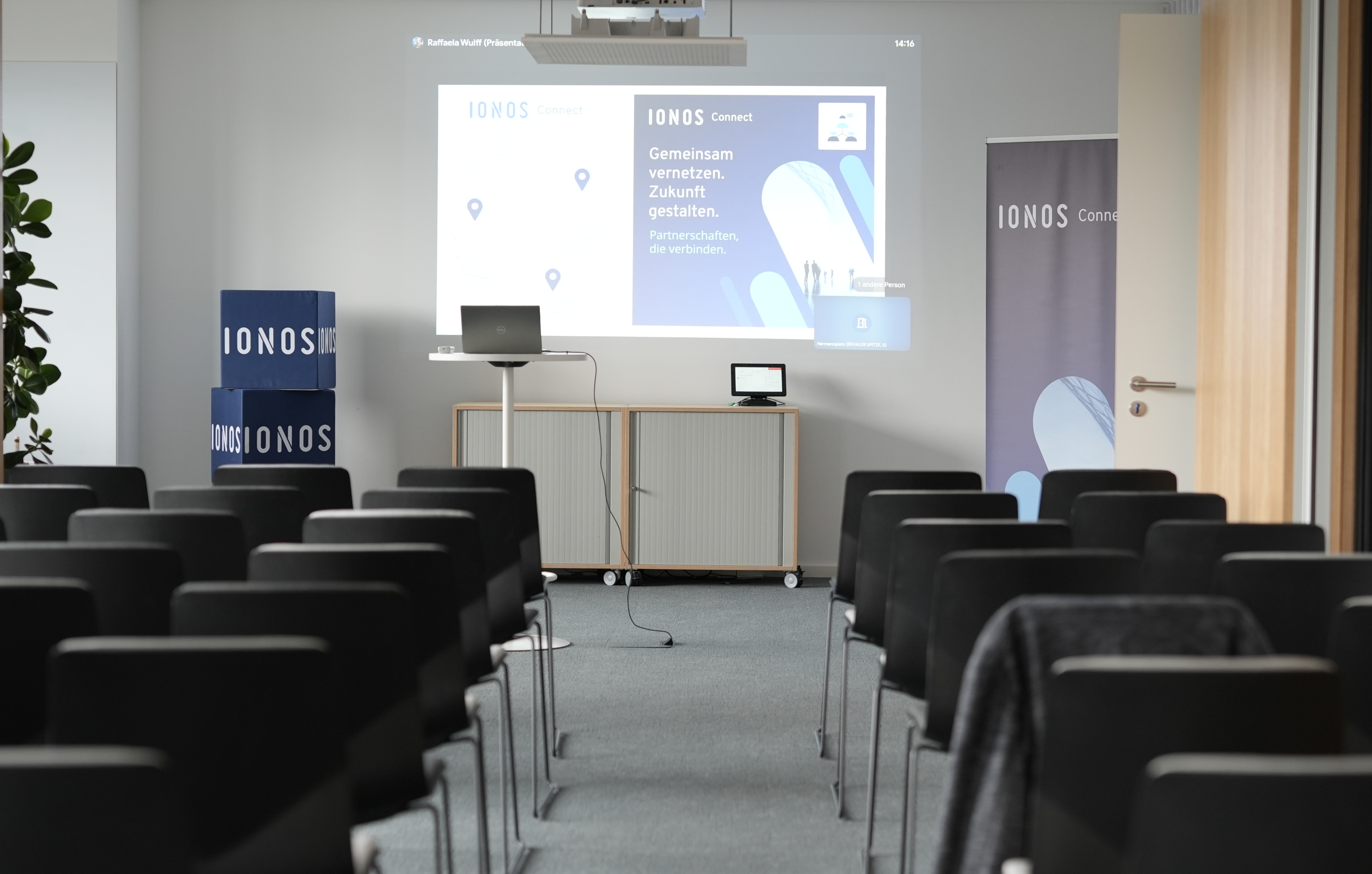 Seminarraum mit Stühlen, Projektor und Präsentation der IONOS Connect.